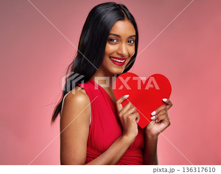 Portrait, heart and valentines day with a woman on a pink background in studio for love or romance. Smile, emoji and social media with a happy young female holding a shape or symbol of affection Portrait, heart and valentines day with a woman on a pink background in studio for love or romance. Smile, emoji and social media with a happy young female holding a shape or symbol of affection 136317610