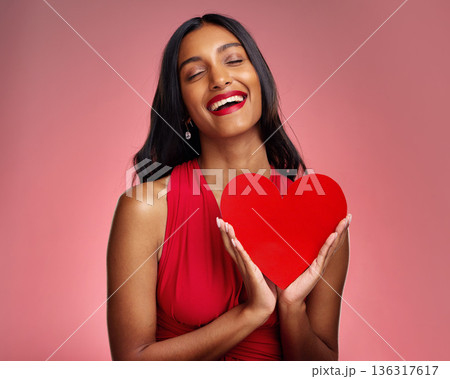 Smile, heart and valentines day with a woman on a pink background in studio for love or romance. Eyes closed, emoji and social media with a happy young female holding a shape or symbol of affection Smile, heart and valentines day with a woman on a pink background in studio for love or romance. Eyes closed, emoji and social media with a happy young female holding a shape or symbol of affection 136317617