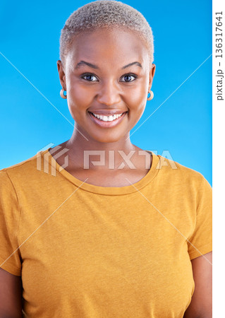 Black woman, smile and happy portrait in studio with a positive mindset, happiness and beauty. Face of an African female model on a blue background for motivation, confidence and natural cosmetics Black woman, smile and happy portrait in studio with a positive mindset, happiness and beauty. Face of an African female model on a blue background for motivation, confidence and natural cosmetics 136317641