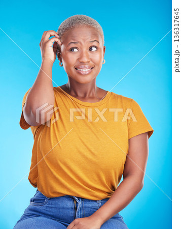 Black woman, scratch head and confused in studio with thinking, mindset or ideas for decision by blue background. African girl, stress and finger on hair for fear, scared and brainstorming for choice 136317645