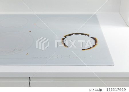 Dirty white ceramic kitchen stove after cooking Dirty white ceramic kitchen stove after cooking 136317669