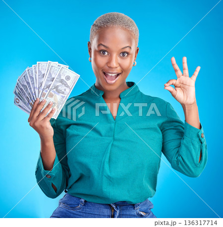 Woman portrait, okay sign and money fan for bonus, financial success and winning, finance loan with wow. African person or winner surprise, yes and notes or cash profit on a studio, blue background 136317714