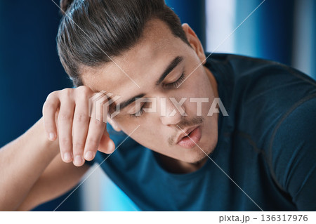 Exercise, sweat and a tired sports man breathing in the gym after an intense or physical workout for health. Fitness, fatigue and a young male athlete or runner finished with his cardio training 136317976