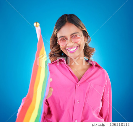 Woman, lgbtq and rainbow flag in studio portrait, sunglasses and icon for pride with human rights by blue background. Gen z girl, lesbian student and wave sign for solidarity, freedom and inclusion Woman, lgbtq and rainbow flag in studio portrait, sunglasses and icon for pride with human rights by blue background. Gen z girl, lesbian student and wave sign for solidarity, freedom and inclusion 136318112