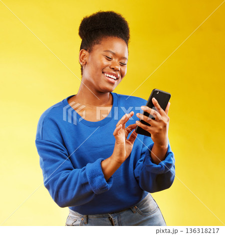 Happy black woman, phone and social media for networking or communication against a yellow studio background. African female person smile for online browsing or chatting on mobile smartphone app Happy black woman, phone and social media for networking or communication against a yellow studio background. African female person smile for online browsing or chatting on mobile smartphone app 136318217