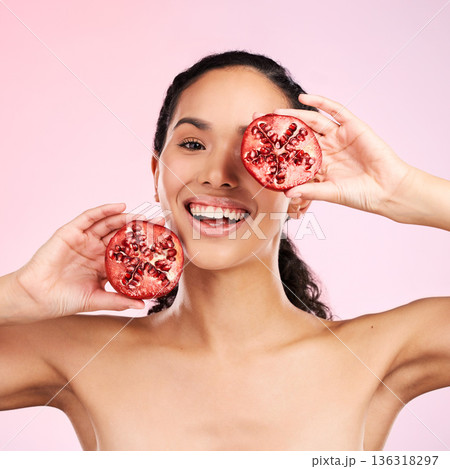 Woman, skincare portrait and pomegranate for beauty, natural cosmetics and facial product or vitamin c benefits. Face of person, red fruits and eye dermatology or skin care on pink, studio background Woman, skincare portrait and pomegranate for beauty, natural cosmetics and facial product or vitamin c benefits. Face of person, red fruits and eye dermatology or skin care on pink, studio background 136318297