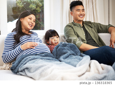Pregnancy, sofa and family in home watching tv with movie, film or show with bonding together. Relax, people and Asian kid with father and pregnant mom for streaming series in living room at house. Pregnancy, sofa and family in home watching tv with movie, film or show with bonding together. Relax, people and Asian kid with father and pregnant mom for streaming series in living room at house. 136318365
