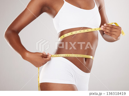 Tape measure, diet and stomach or body of woman for health and wellness on studio background. Fitness, progress or underwear and waist of aesthetic female model for weight loss, balance or motivation 136318419