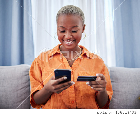 Home, phone or happy black woman with credit card or phone on payment on internet website or fintech. Online shopping, finance or excited African girl typing in money transfer via mobile banking Home, phone or happy black woman with credit card or phone on payment on internet website or fintech. Online shopping, finance or excited African girl typing in money transfer via mobile banking 136318433