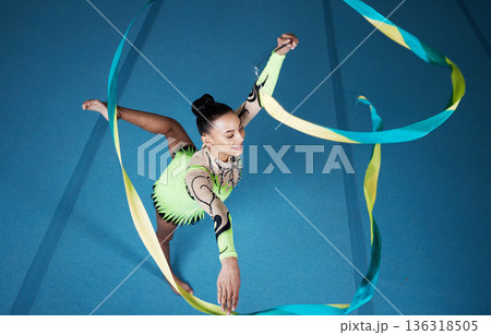 Rhythmic gymnastics, woman in gym and ribbon with balance, action with performance and fitness. Competition, athlete and female gymnast, creativity and art with dancing routine and energy at arena 136318505