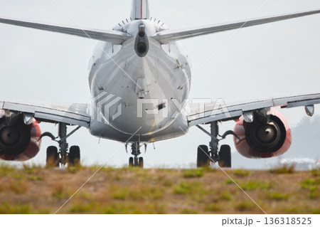 A huge passenger plane pulls onto the runway of Thailand airport, a view through the fence A huge passenger plane pulls onto the runway of Thailand airport, a view through the fence 136318525