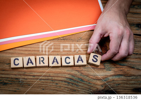 CARACAS Economic Crisis Concept Shown With Wooden Letter Blocks And Hand CARACAS Economic Crisis Concept Shown With Wooden Letter Blocks And Hand 136318536