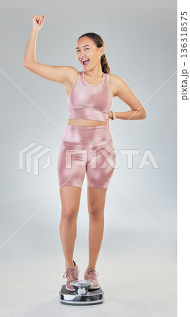 Scale, success and woman in portrait for fitness, lose weight progress and body or fist, power and bodybuilder goals. Sports person or model with balance, diet and yes sign on studio white background Scale, success and woman in portrait for fitness, lose weight progress and body or fist, power and bodybuilder goals. Sports person or model with balance, diet and yes sign on studio white background 136318575