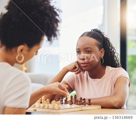 Chess, friends and women with board for game moving piece for strategy, thinking and challenge. Competition, planning and African female people with chessboard in living room playing to checkmate Chess, friends and women with board for game moving piece for strategy, thinking and challenge. Competition, planning and African female people with chessboard in living room playing to checkmate 136318669