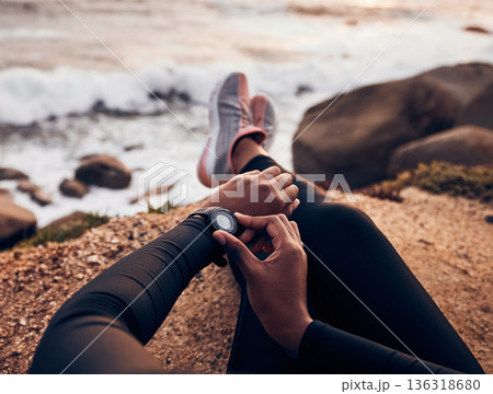 Relax, check and smart watch with hand of woman on rock for running, fitness tracker and heart rate. Workout, exercise and goal with closeup of female runner at beach for monitor, goals and time 136318680