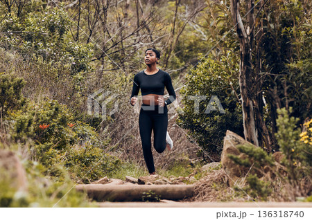 Forest, running and woman of fitness, body training and cardio wellness, outdoor challenge or hiking in nature. Runner, athlete or african sports person for workout goal or marathon exercise in woods 136318740