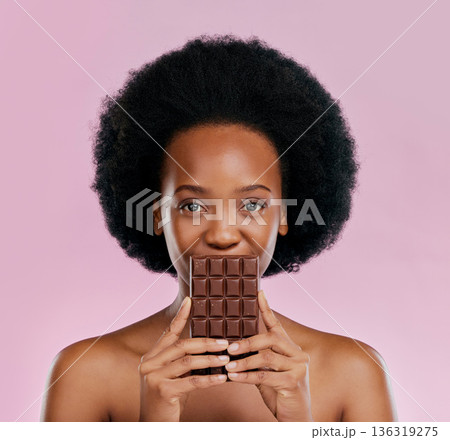 Portrait, chocolate and black woman with snack, natural beauty and sugar treat on a studio background. Face, female person or Jamaican model with sweets, cocoa candy and delicious snack with calories Portrait, chocolate and black woman with snack, natural beauty and sugar treat on a studio background. Face, female person or Jamaican model with sweets, cocoa candy and delicious snack with calories 136319275