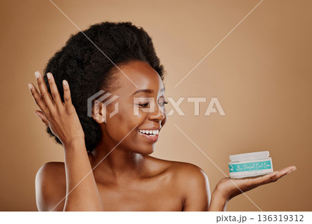 Happy, thinking and a black woman with a product for hair care, wellness and shine. Smile, beauty and an African girl or model with a vision for afro cosmetics in a container on a studio background 136319312
