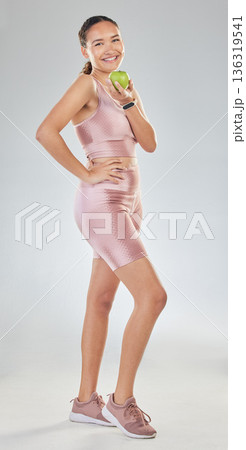 Portrait, smile and fitness woman with apple in studio isolated on a white background. Sports athlete, fruit and person with food for healthy diet, nutrition or wellness, body care and vitamin c. 136319541