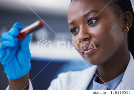 Science, blood vial and female scientist in a lab working on a medical experiment, test or exam. Biotechnology, pharmaceutical and African woman researcher doing scientific research in a laboratory. 136319593