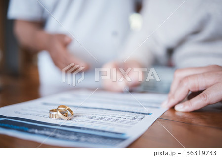 Family law, divorce and marriage court for couple with a contract, document or legal paperwork to sign agreement. Ring, deal and people together in conflict in an attorney office for a break up Family law, divorce and marriage court for couple with a contract, document or legal paperwork to sign agreement. Ring, deal and people together in conflict in an attorney office for a break up 136319733