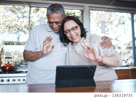 Technology, mature couple with tablet and video call in kitchen of their home for connectivity. Social networking or online communication, retirement house or happiness and senior people wave hello Technology, mature couple with tablet and video call in kitchen of their home for connectivity. Social networking or online communication, retirement house or happiness and senior people wave hello 136319735