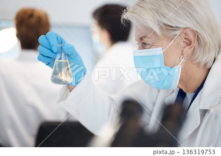 Science, sample and a senior doctor woman at work in a laboratory for research or innovation in healthcare. Face, covid mask and a mature female scientist working in a lab for medical development 136319753