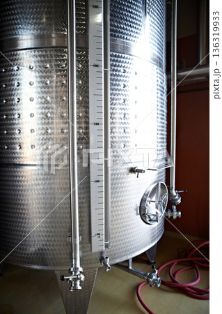 Beer tank, machine and manufacturing plant for alcohol with steel container for liquor. Metal, wine fermentation and drum in a factory company with brewery equipment and drink at a distillery Beer tank, machine and manufacturing plant for alcohol with steel container for liquor. Metal, wine fermentation and drum in a factory company with brewery equipment and drink at a distillery 136319933