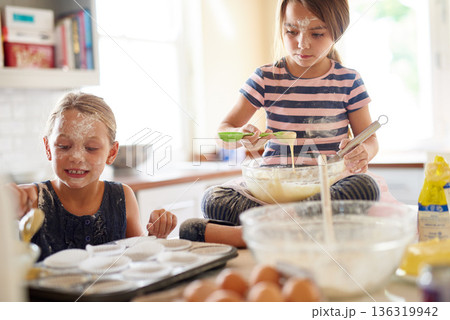Learning, playing or messy children baking in kitchen with siblings mixing flour in bowl at home together. Smile, happy or dirty kids cooking or teaching a fun daughter to bake for child development 136319942