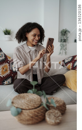 Lady Evaluates Her Pending Orders Quietly, Woman Seated On Sofa Reviews And Manages Her Order List Lady Evaluates Her Pending Orders Quietly, Woman Seated On Sofa Reviews And Manages Her Order List 136320186