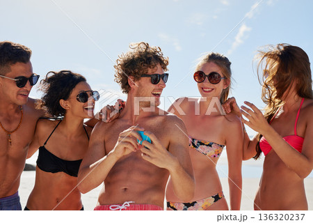Social media, travel and friends on the beach with a phone to post a status update while on vacation together. Mobile, freedom and a group of young people outdoor in nature for summer holiday 136320237