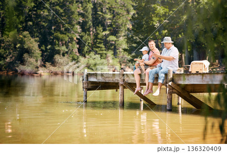 Father, grandfather and child fishing at lake together for fun bonding or peaceful time in nature outdoors. Dad, grandpa and kid enjoying life, catch or fish with rod by water pond or river in forest Father, grandfather and child fishing at lake together for fun bonding or peaceful time in nature outdoors. Dad, grandpa and kid enjoying life, catch or fish with rod by water pond or river in forest 136320409