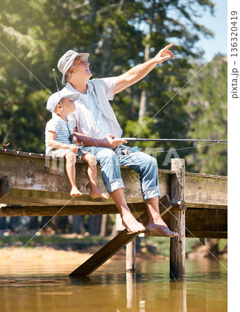 Grandfather, child and pointing while fishing at lake for fun hobby, adventure and teaching about nature. Boy kid, view and learning to fish with senior man at river, camping trip and happy vacation Grandfather, child and pointing while fishing at lake for fun hobby, adventure and teaching about nature. Boy kid, view and learning to fish with senior man at river, camping trip and happy vacation 136320419