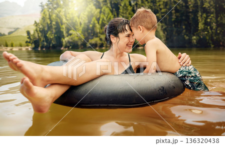 Lake, inflatable ring and mother with child in water while camping in a forest for vacation or holiday together. Travel, swimming and parent bonding with kid in nature for freedom, love and happiness Lake, inflatable ring and mother with child in water while camping in a forest for vacation or holiday together. Travel, swimming and parent bonding with kid in nature for freedom, love and happiness 136320438