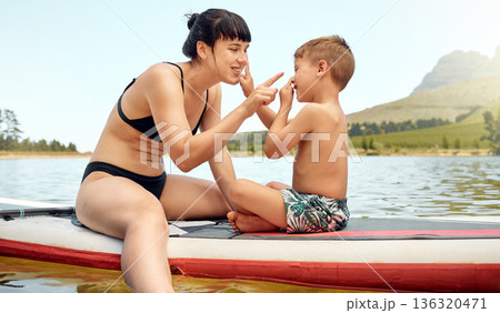 Lake, nature with mother and son on paddle board, relax outdoor with summer holiday and travel. Adventure, freedom and fun, family with woman and boy child in swimsuit, vacation and bonding together Lake, nature with mother and son on paddle board, relax outdoor with summer holiday and travel. Adventure, freedom and fun, family with woman and boy child in swimsuit, vacation and bonding together 136320471