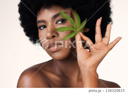 African woman, leaf and weed in studio portrait for wellness, cosmetics or skincare by white background. Girl, model and hemp for beauty, makeup or natural plant for skin aesthetic, afro and health 136320615