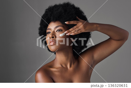 Beauty, skincare and black woman with cream on face, afro and cosmetics in studio on grey background. Natural skin care product, lotion and African model with salon glow and dermatology for wellness. 136320631