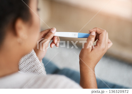 Pregnancy test, woman hands and waiting at home for results on a living room couch. House, female person and hand with testing stick to show pregnant sign while checking alone on lounge sofa Pregnancy test, woman hands and waiting at home for results on a living room couch. House, female person and hand with testing stick to show pregnant sign while checking alone on lounge sofa 136320972