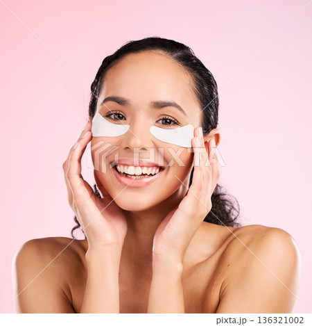 Face, eye patch and beauty of a woman with natural skin glow on a pink background. Dermatology, collagen mask or cosmetics portrait of female model for facial shine, wellness or self care in studio Face, eye patch and beauty of a woman with natural skin glow on a pink background. Dermatology, collagen mask or cosmetics portrait of female model for facial shine, wellness or self care in studio 136321002