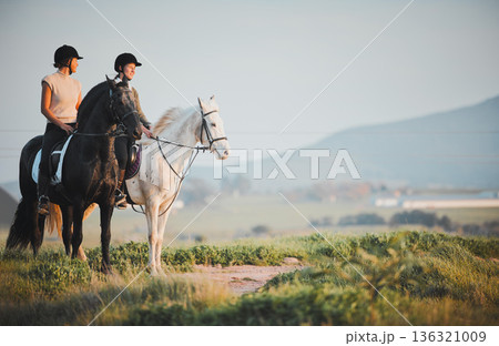 Horse riding, freedom and view with friends in nature on horseback enjoying their hobby during a summer morning. Countryside, equestrian and female riders outdoor together for adventure or bonding Horse riding, freedom and view with friends in nature on horseback enjoying their hobby during a summer morning. Countryside, equestrian and female riders outdoor together for adventure or bonding 136321009