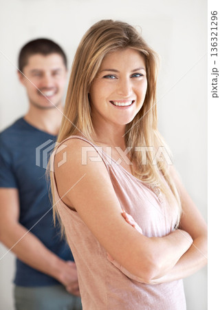 Smile, portrait and couple having fun in living room with arms crossed, pose and laughing in their home together. Face, happy woman and man bond of day off in their house, proud and chilling together 136321296