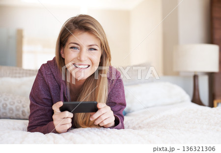 Teenager, girl in portrait and smartphone with games and relax in bedroom, smile with technology and esports. Young female person at home, gaming and mobile app with happiness, gen z and internet Teenager, girl in portrait and smartphone with games and relax in bedroom, smile with technology and esports. Young female person at home, gaming and mobile app with happiness, gen z and internet 136321306