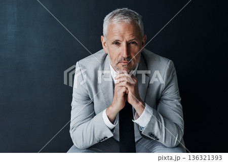 Serious portrait of senior attorney sitting with confidence, mockup space and dark background in studio. Pride, professional career ceo and executive lawyer man, mature businessman or law firm boss. 136321393