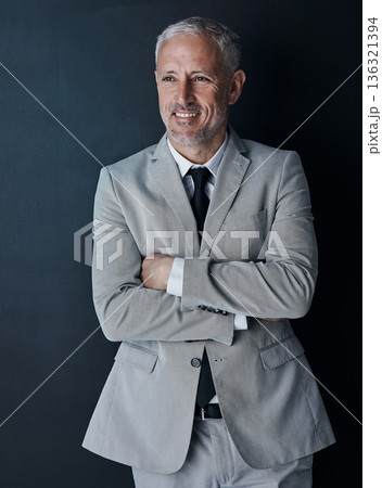 Senior businessman in suit, arms crossed and smile on dark background, happy lawyer in studio. Confidence, pride and professional career for executive ceo attorney, business owner and law firm boss. Senior businessman in suit, arms crossed and smile on dark background, happy lawyer in studio. Confidence, pride and professional career for executive ceo attorney, business owner and law firm boss. 136321394