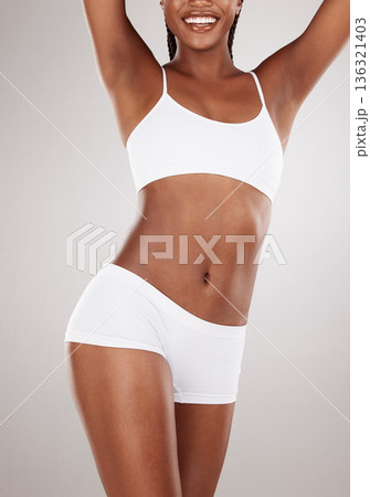 Body, stomach and a happy woman in underwear for health and wellness on a white studio background. Fitness, skincare and strong female model on a diet for weight loss, balance or motivation Body, stomach and a happy woman in underwear for health and wellness on a white studio background. Fitness, skincare and strong female model on a diet for weight loss, balance or motivation 136321403