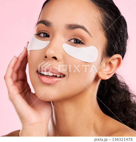 Eye patch, face mask and beauty of a woman with natural skin glow on a pink background. Dermatology, collagen and cosmetics portrait of female model for facial shine, wellness or self care in studio Eye patch, face mask and beauty of a woman with natural skin glow on a pink background. Dermatology, collagen and cosmetics portrait of female model for facial shine, wellness or self care in studio 136321478
