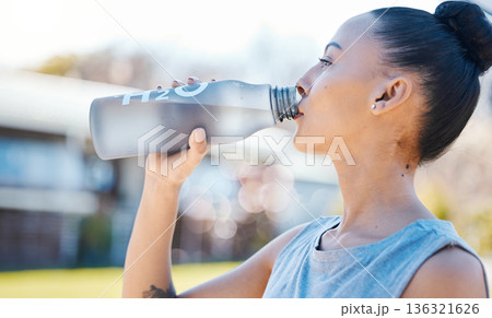 Drinking water, fitness and woman for outdoor training, exercise and workout nutrition, health or wellness in park. Tired runner or athlete person with liquid bottle for running energy and cardio Drinking water, fitness and woman for outdoor training, exercise and workout nutrition, health or wellness in park. Tired runner or athlete person with liquid bottle for running energy and cardio 136321626