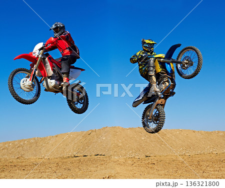 Motorcycle jump, sport and action with stunt and energy on off road track, transportation and people race outdoor. Competition, dirt bike and performance with adrenaline, exercise and challenge 136321800