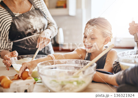 Learning, playing or messy kid baking in kitchen with a young girl smiling with flour on a dirty face at home. Smile, happy or parent cooking or teaching a fun daughter to bake for child development Learning, playing or messy kid baking in kitchen with a young girl smiling with flour on a dirty face at home. Smile, happy or parent cooking or teaching a fun daughter to bake for child development 136321924