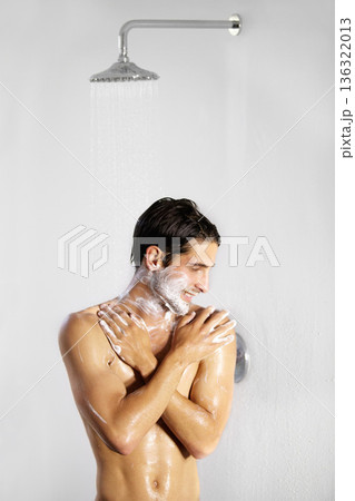 Shower, man and home with body cleaning and soap in the morning in bathroom. Water, young male person and smile with hygiene and clean skin care in a house with cosmetic grooming and shaving foam Shower, man and home with body cleaning and soap in the morning in bathroom. Water, young male person and smile with hygiene and clean skin care in a house with cosmetic grooming and shaving foam 136322013